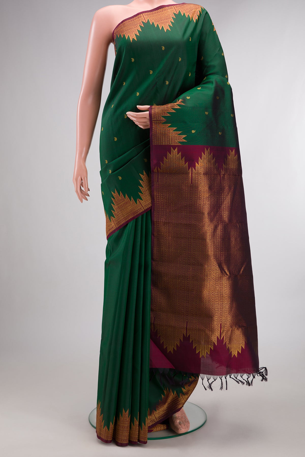 Pure Silk Bottle Green Kanchipuram Saree with Zari Butta on the body and Temple Border.  displayed on a mannequin