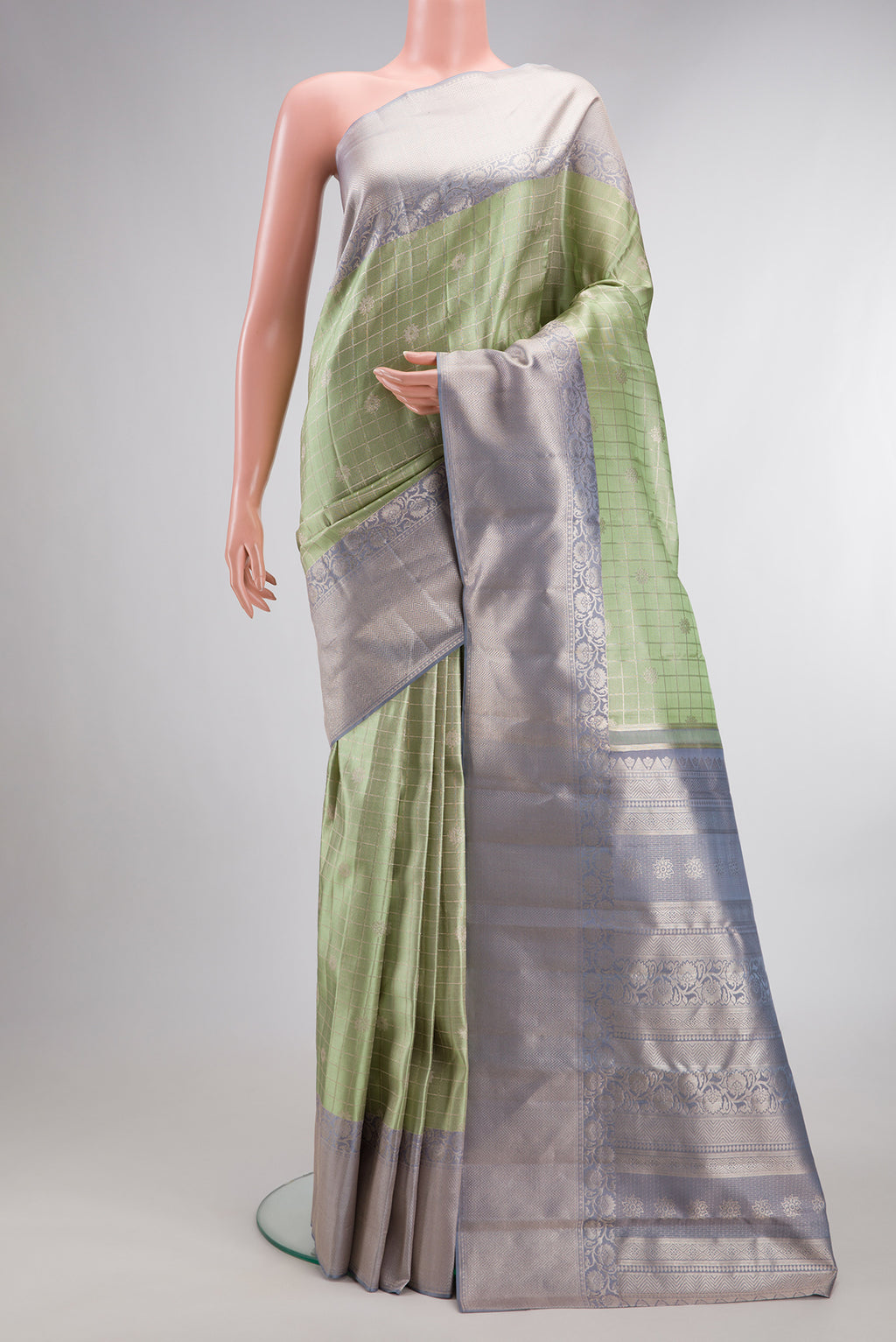 Pista Green Kanchipuram Tissue Saree with Checked design on the body and Fancy Border.  displayed on a mannequin