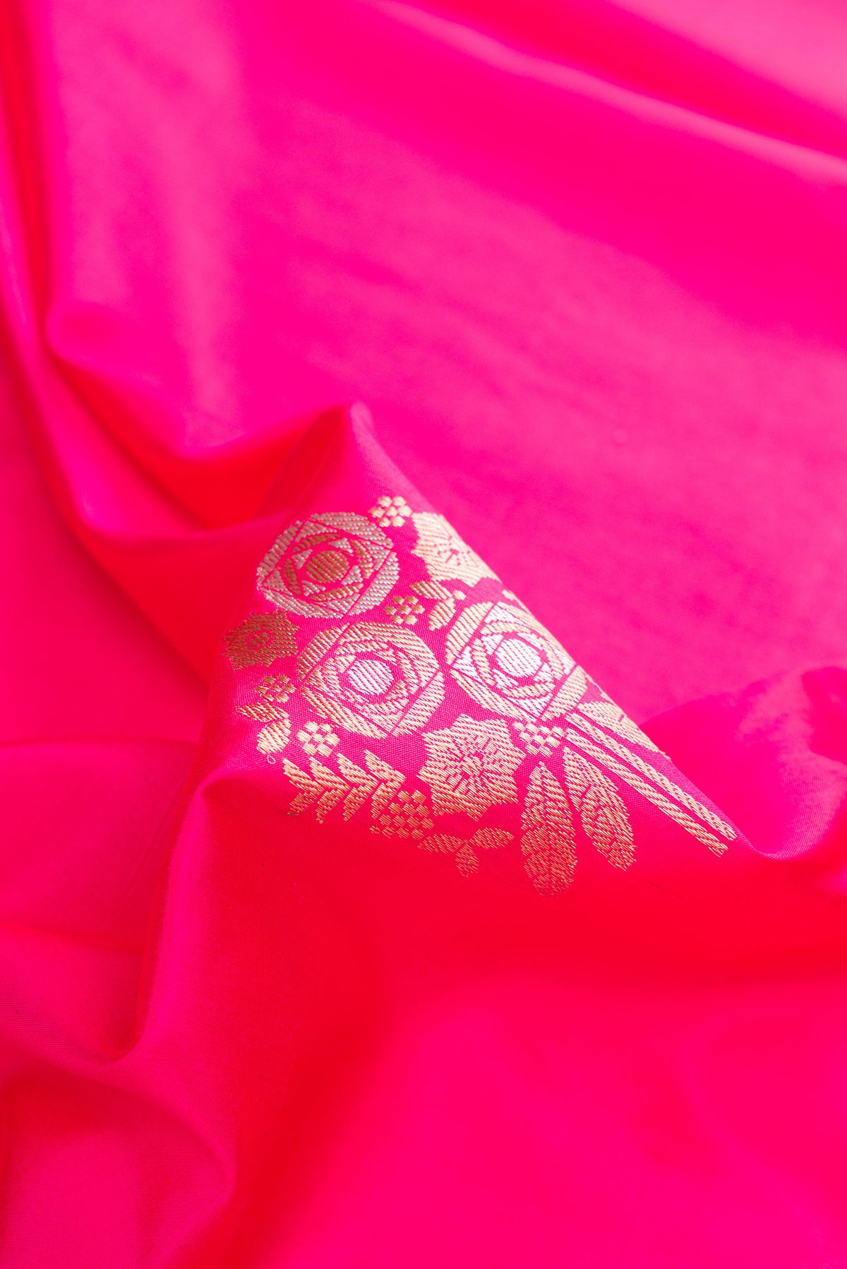 Close up of Pure Silk Pink Banarasi Saree with Zari Butta on the body and Zari Border.  displaying folds