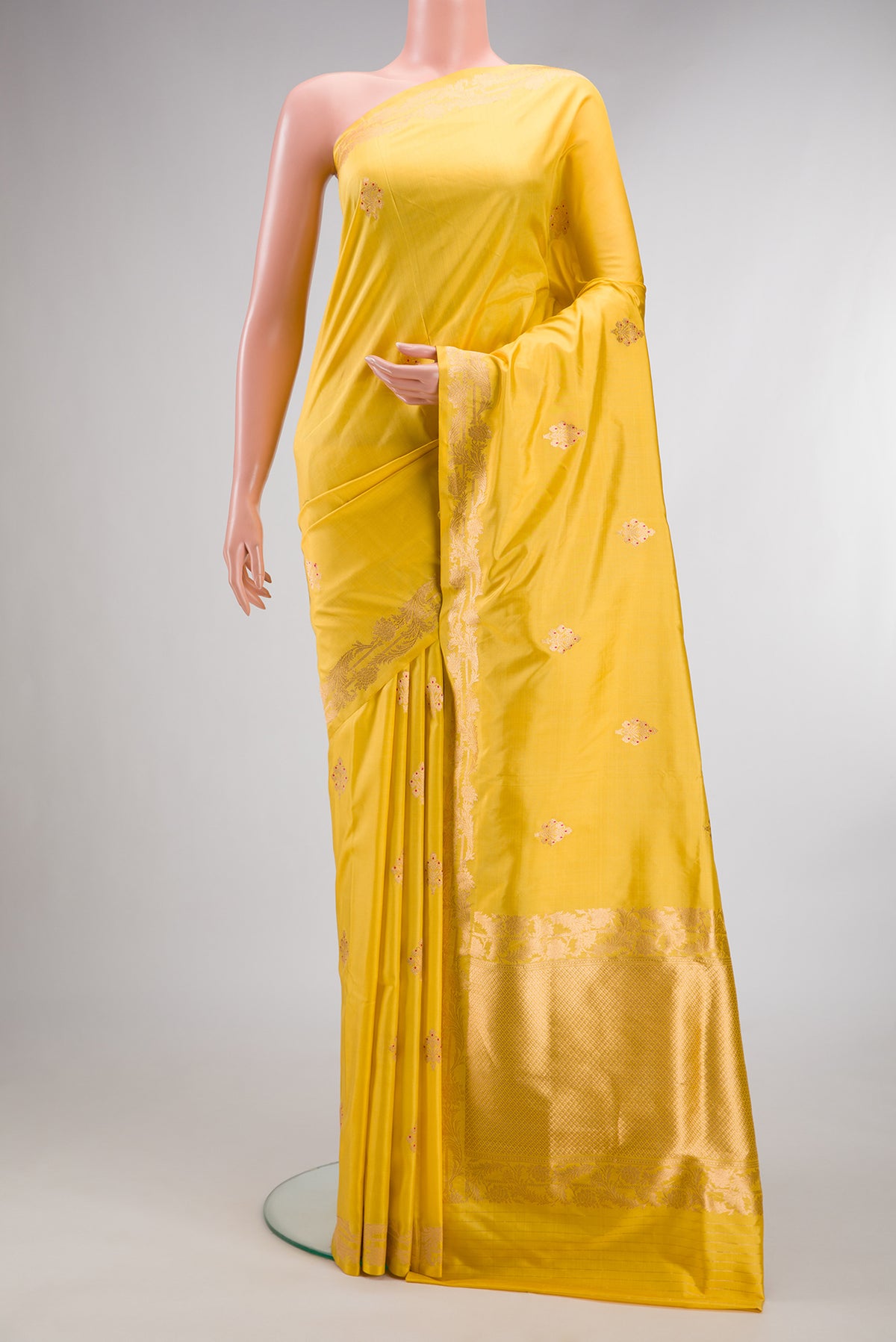 Pure Silk Yellow Banarasi Saree with Zari Butta on the body and Zari Border.  displayed on a mannequin