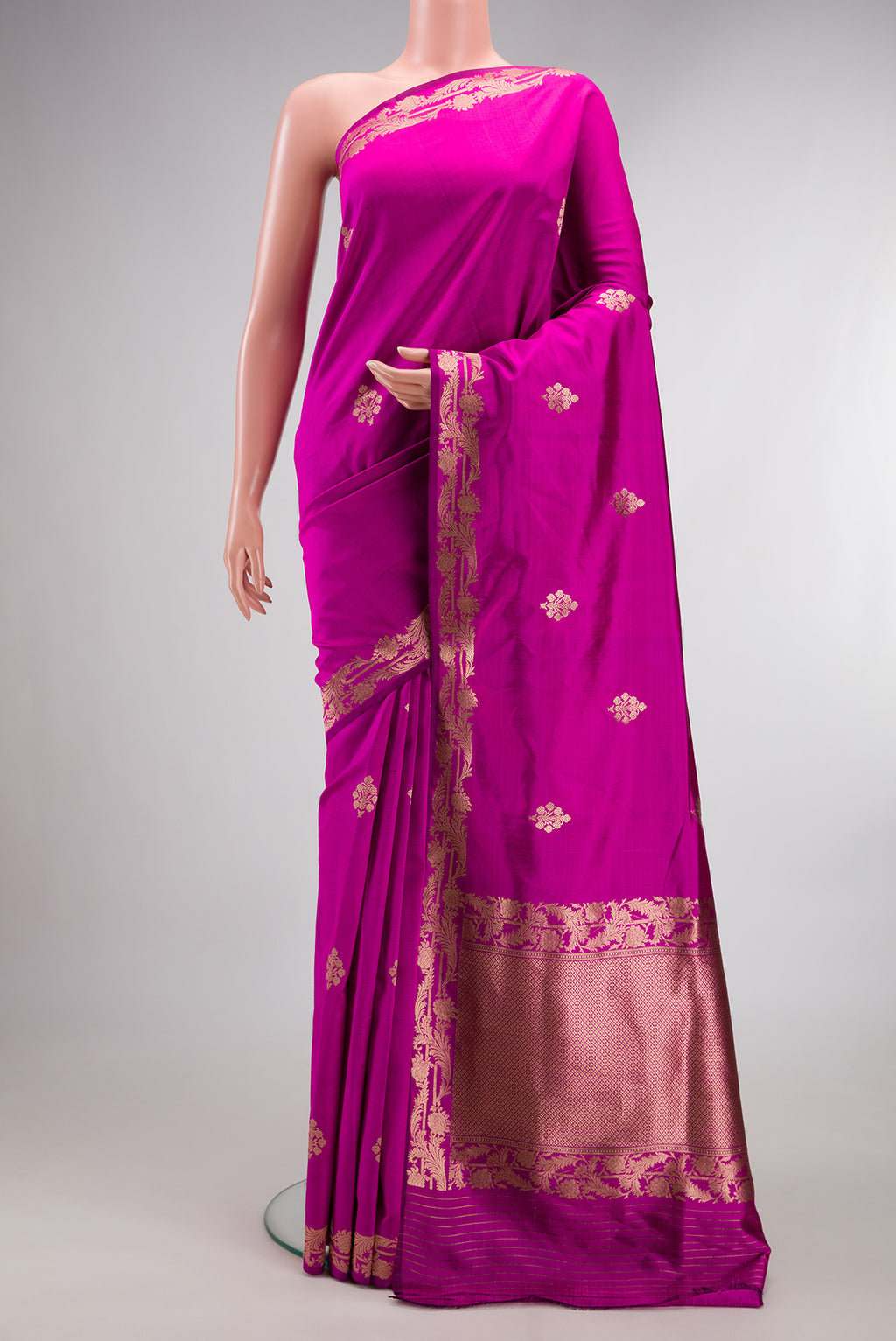 Pure Silk Rani Pink Banarasi Saree with Zari Butta on the body and Zari Border.  displayed on a mannequin