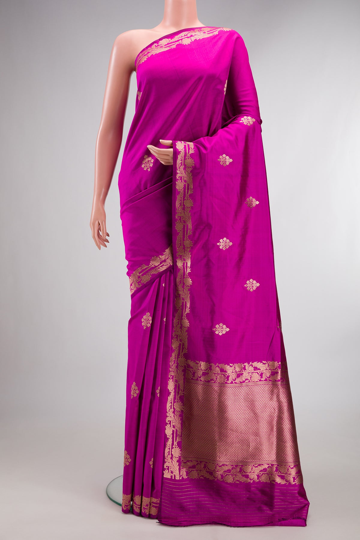 Pure Silk Rani Pink Banarasi Saree with Zari Butta on the body and Zari Border.  displayed on a mannequin