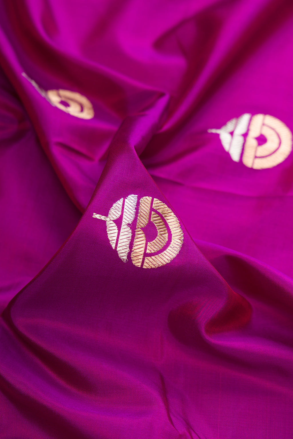 Close up of Pure Silk Magenta Banarasi Saree with Zari Butta on the body and Zari Border.  displaying folds