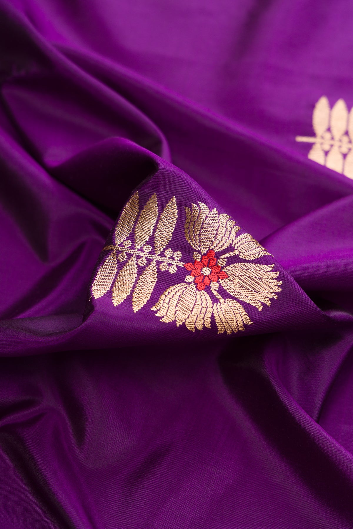 Close up of Pure Silk Violet Banarasi Saree with Zari And Thread Butta on the body and Zari Border.  displaying folds