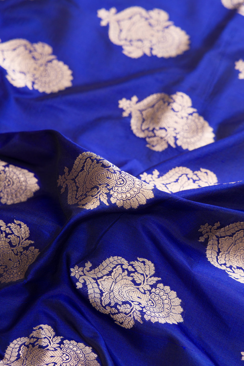 Close up of Pure Silk Royal Blue Banarasi Saree with Zari Butta on the body and Zari Border.  displaying folds