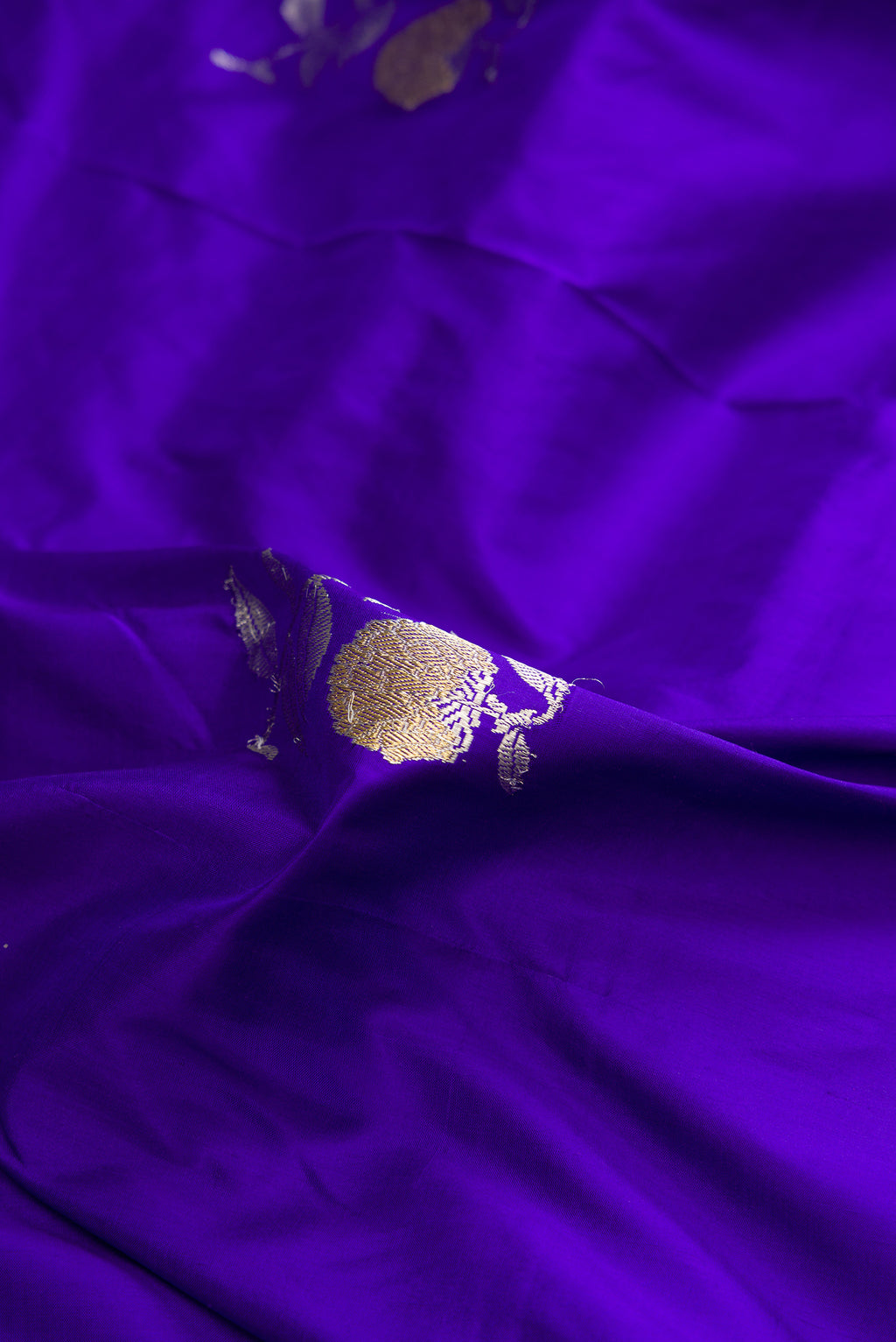 Close up of Pure Silk Royal Blue Banarasi Saree with Zari Butta on the body and Zari Border.  displaying folds