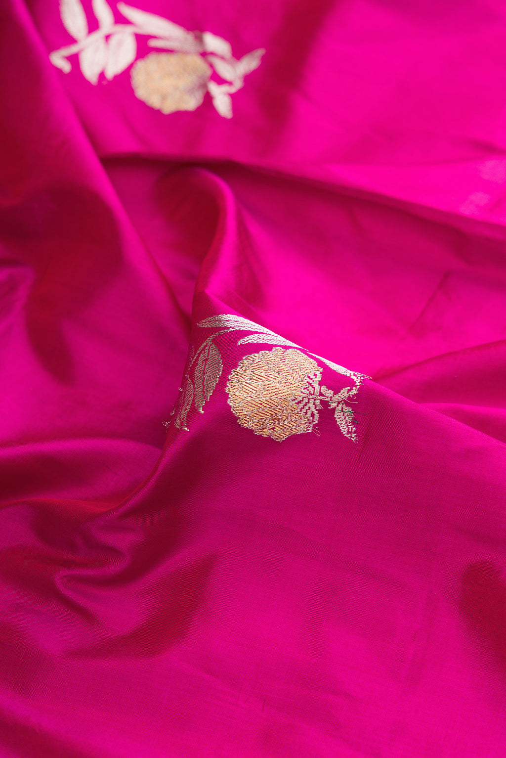 Close up of Pure Silk Magenta Dual Tone Banarasi Saree with Zari Butta on the body and Zari Border.  displaying folds