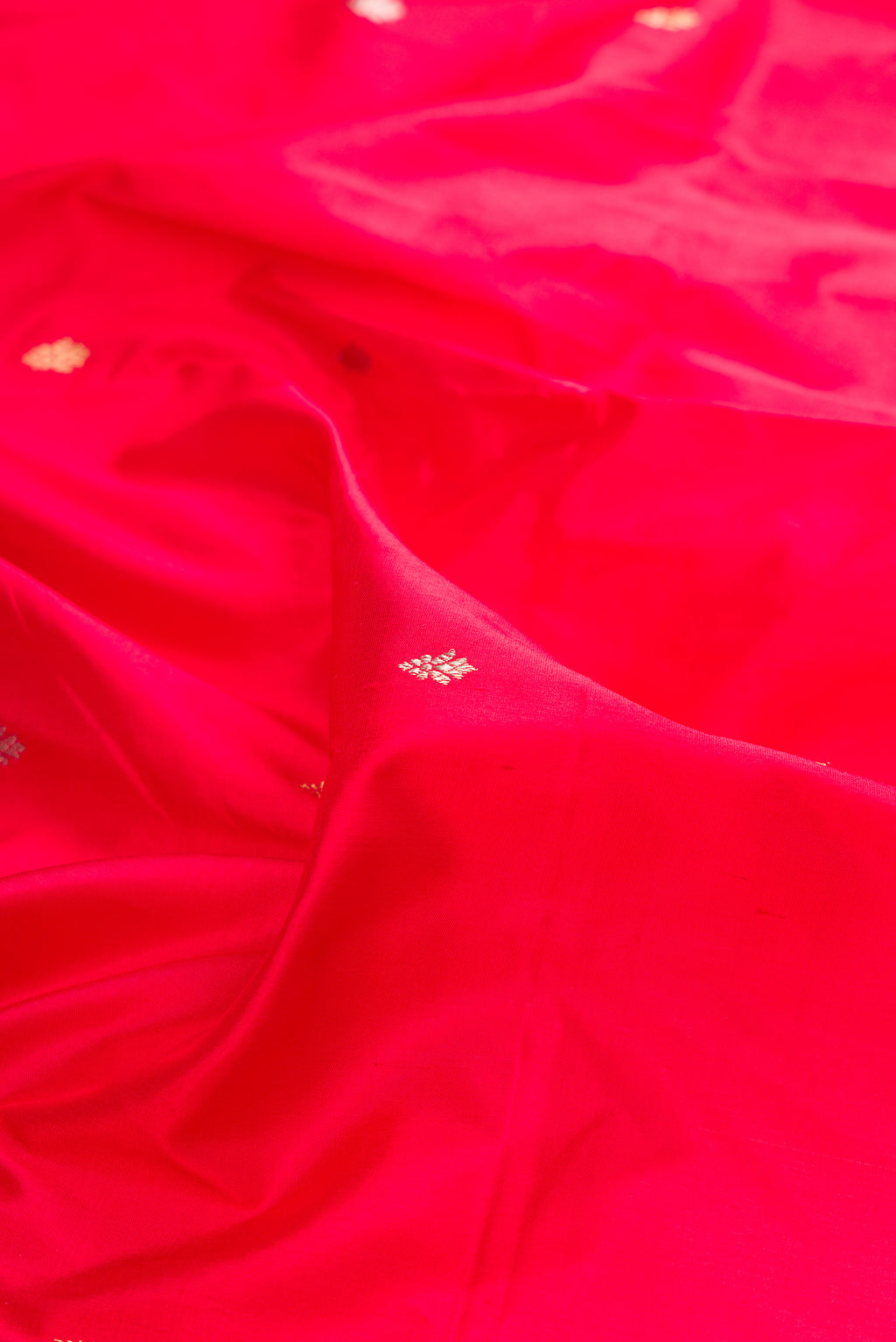 Close up of Pure Silk Red Banarasi Saree with Zari Butta on the body and Fancy Border.  displaying folds