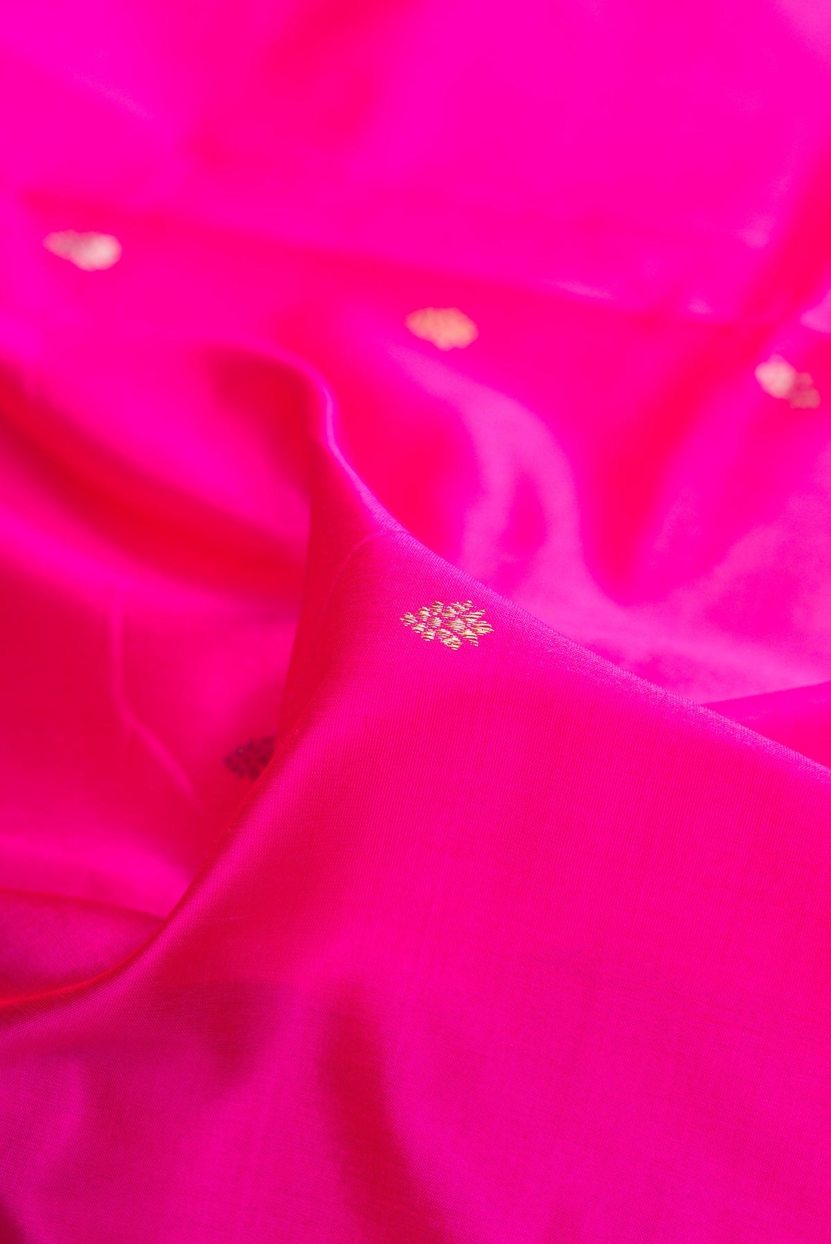 Close up of Pure Silk Dark Pink Banarasi Saree with Zari Butta on the body and Fancy Border.  displaying folds