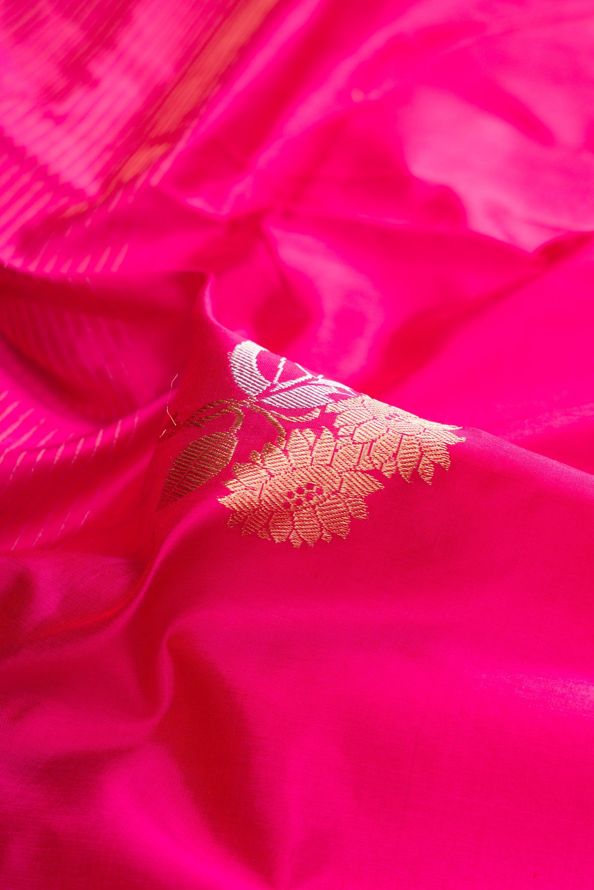 Close up of Pure Silk Dark Pink Dual Tone Banarasi Saree with Zari Butta on the body and Fancy Border.  displaying folds