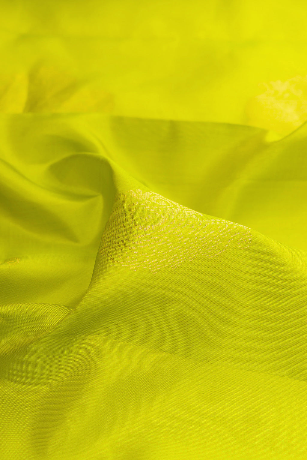 Close up of Pure Silk Parrot Green Soft Saree with Zari Butta on the body and Zari Border.  displaying folds