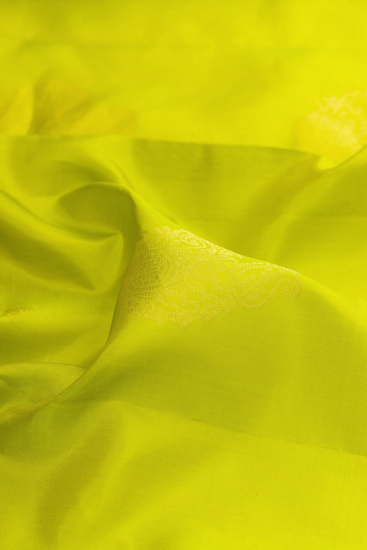 Close up of Pure Silk Parrot Green Soft Saree with Zari Butta on the body and Zari Border.  displaying folds