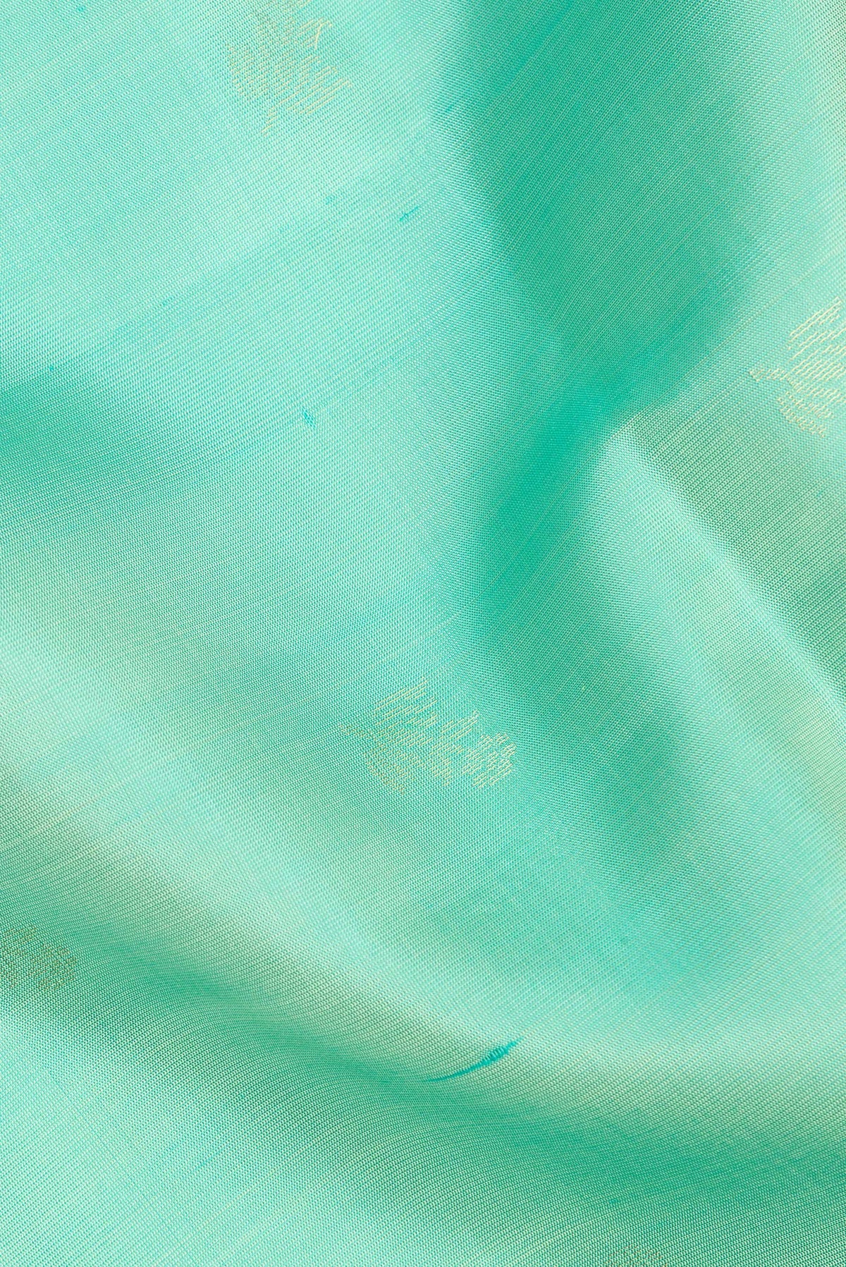 Close up of Pure Silk Sea Green Soft Saree with Zari Butta on the body and Zari Border.  displaying folds
