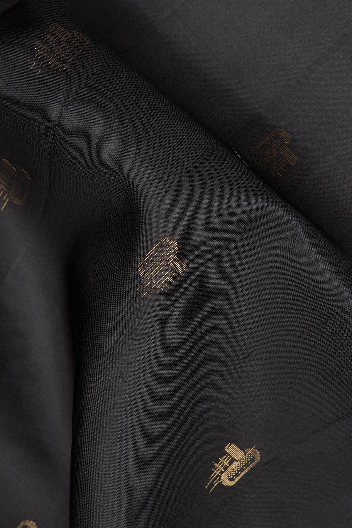 Close up of Pure Silk Black Soft Saree with Zari Butta on the body and Zari Border.  displaying folds