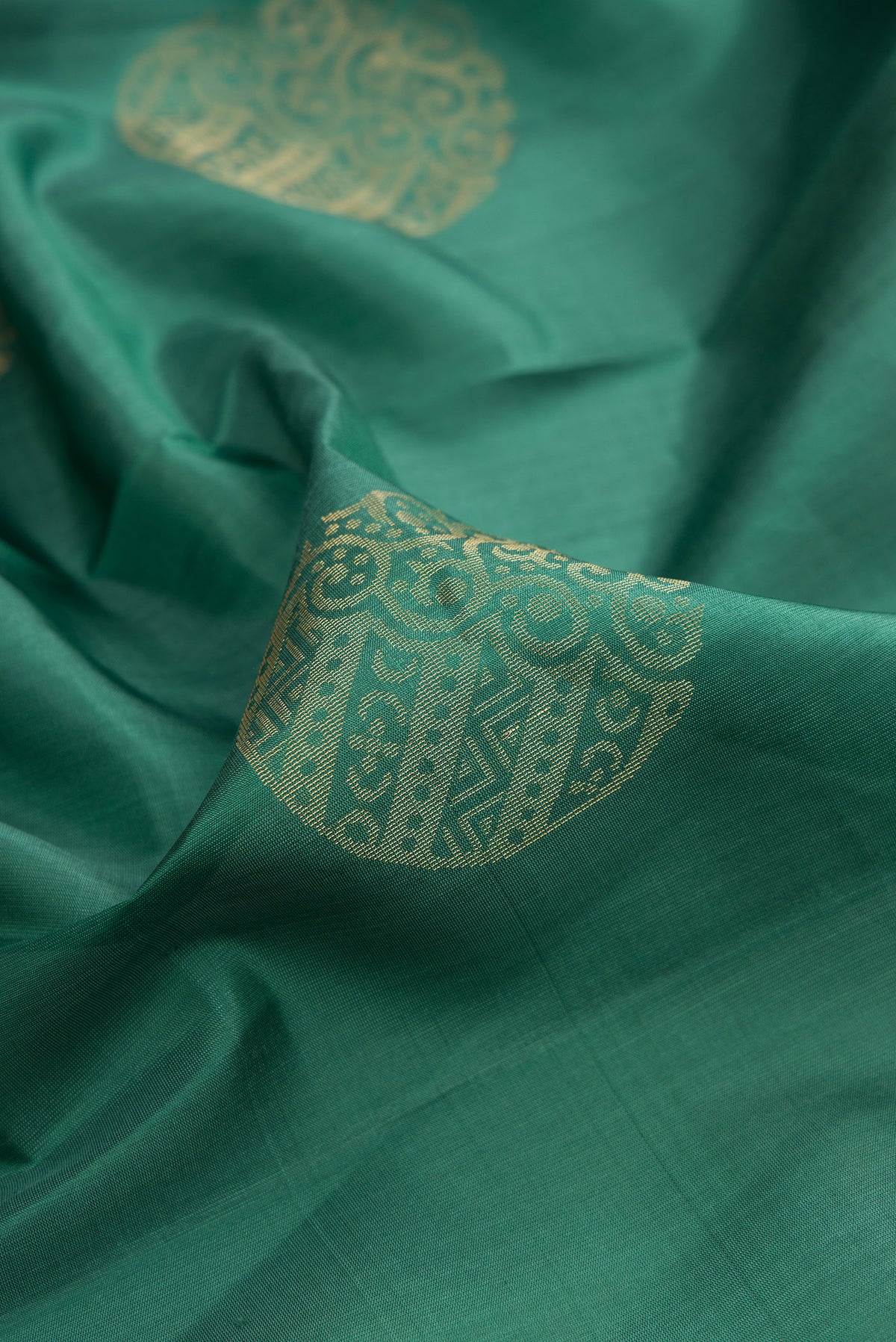 Close up of Pure Silk Green Soft Saree with Zari Butta on the body and Zari Border.  displaying folds