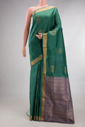 Pure Silk Green Soft Saree with Zari Butta on the body and Zari Border.  displayed on a mannequin