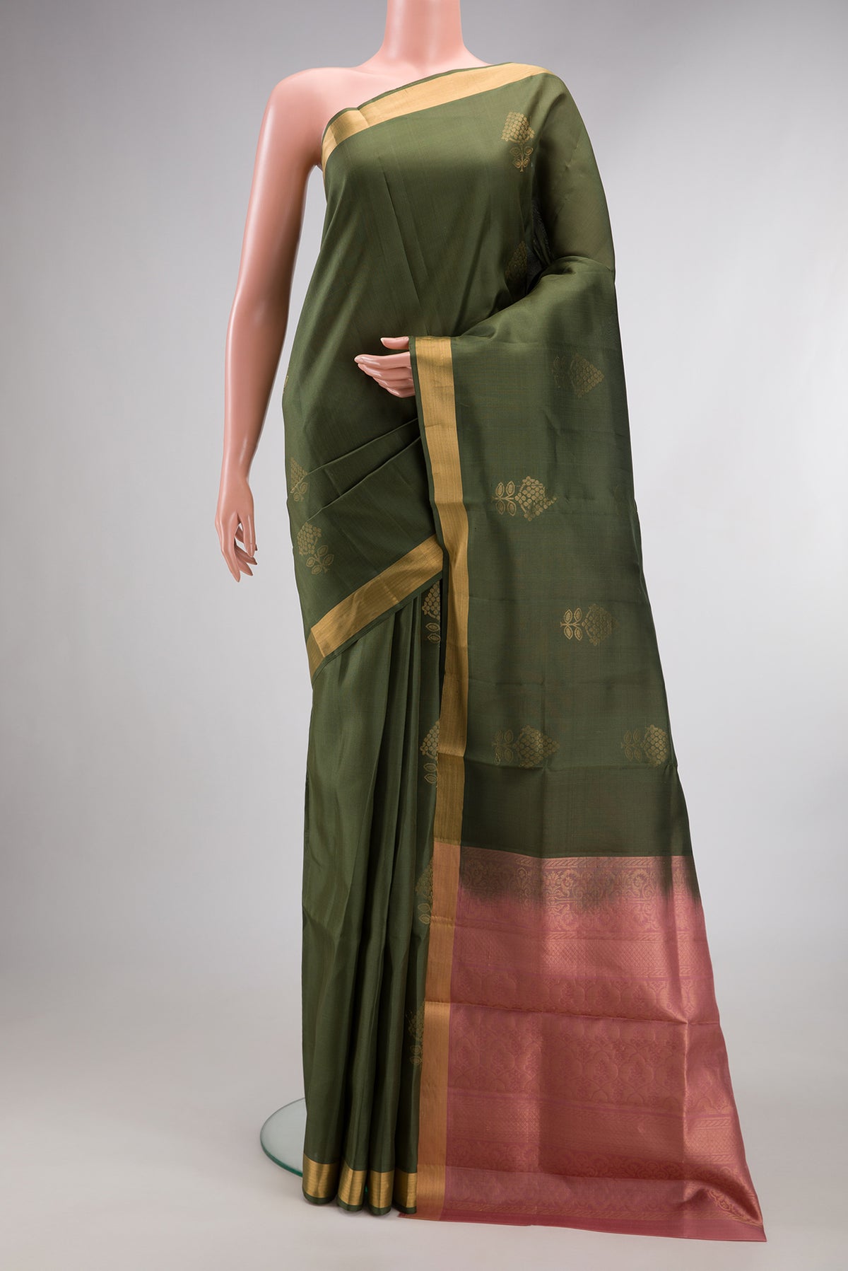 Pure Silk Mehandi Green Soft Saree with Zari Butta on the body and Zari Border.  displayed on a mannequin