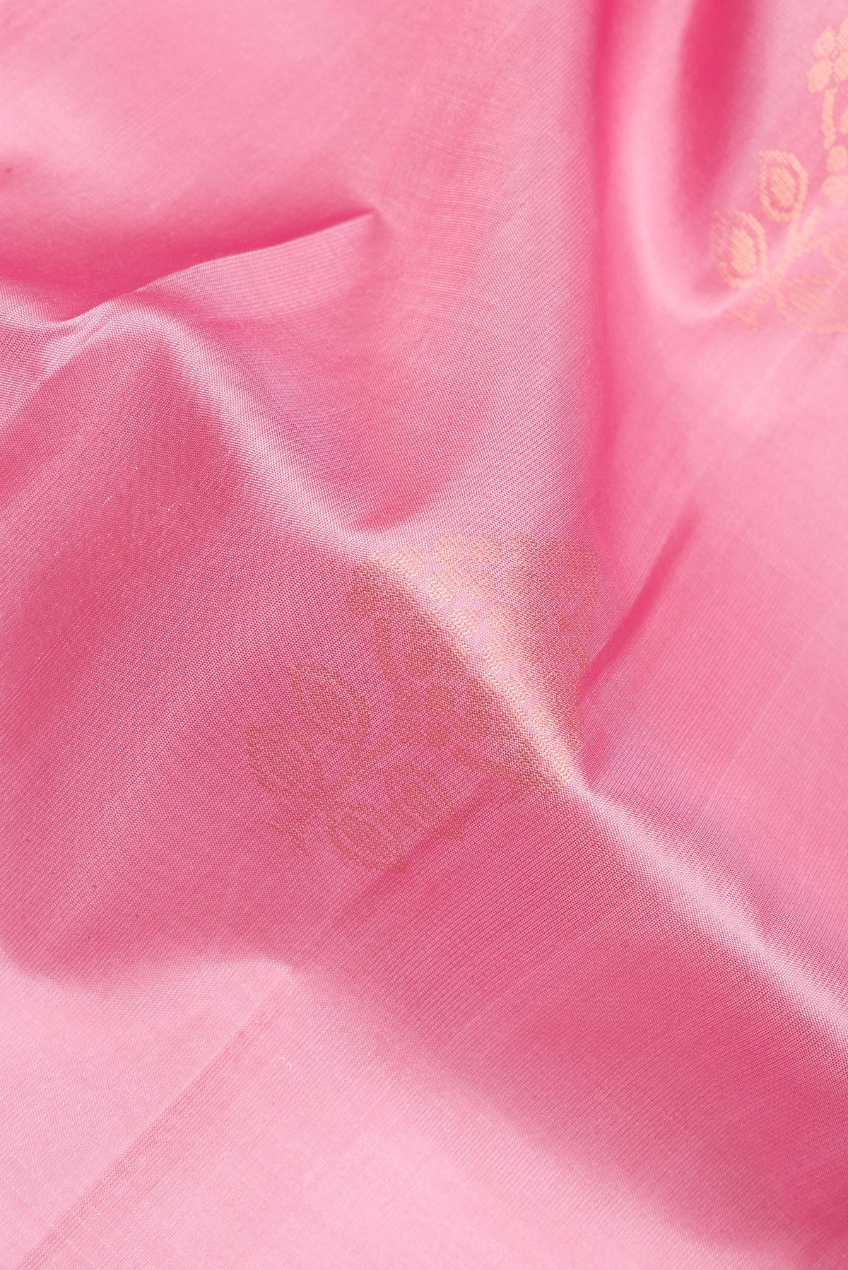 Close up of Pure Silk Rose Gold Soft Saree with Zari Butta on the body and Zari Border.  displaying folds