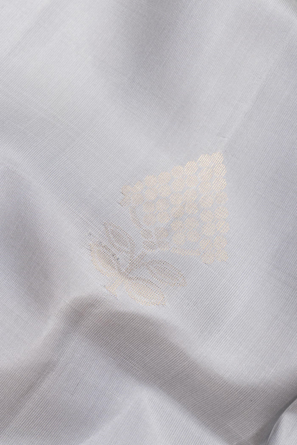 Close up of Pure Silk Grey Soft Saree with Zari Butta on the body and Zari Border.  displaying folds