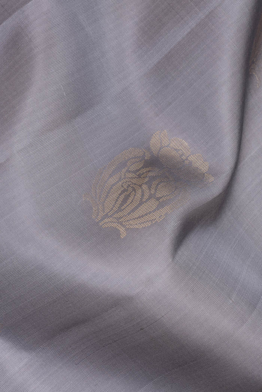 Close up of Pure Silk Grey Soft Saree with Zari Butta on the body and Zari Border.  displaying folds