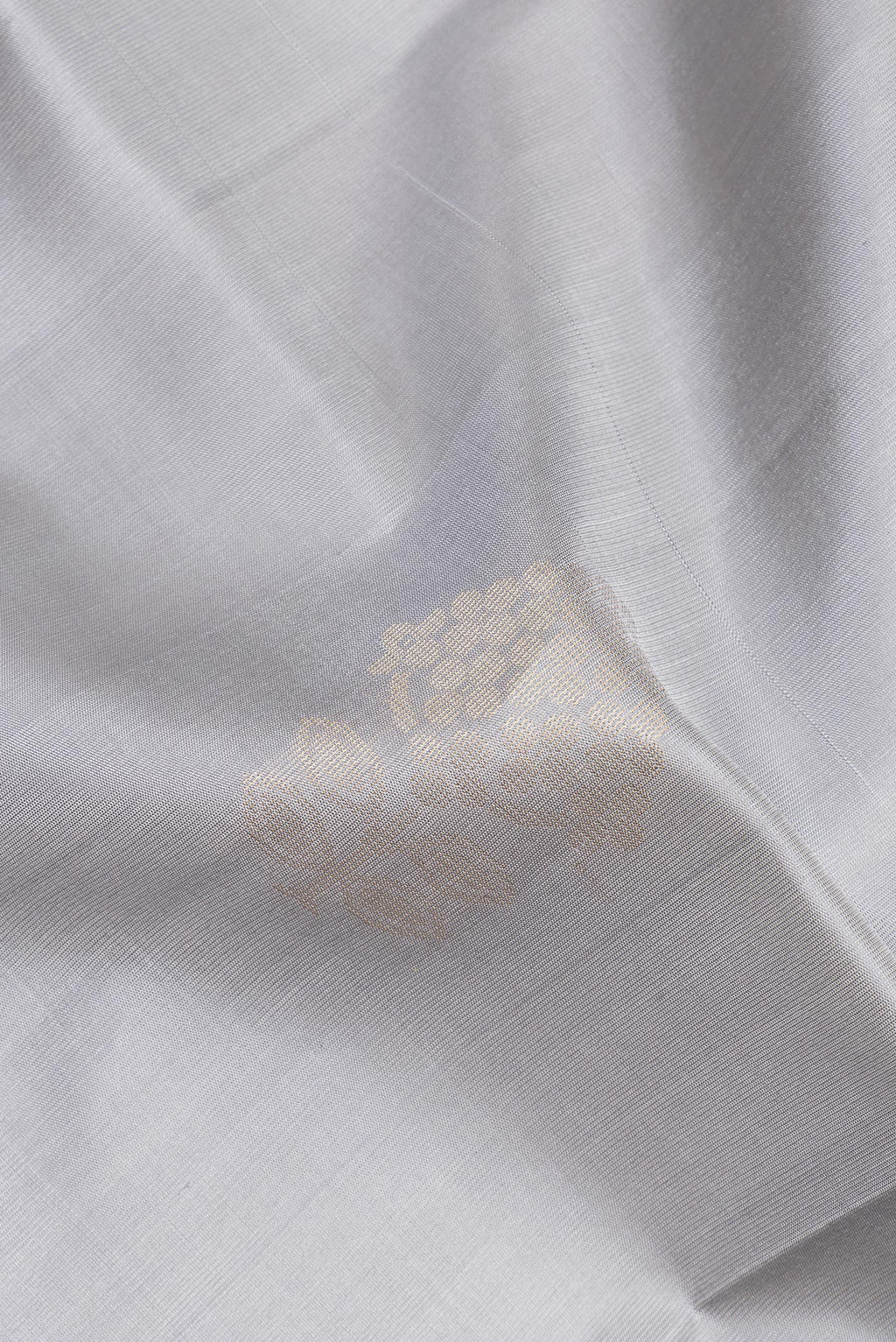 Close up of Pure Silk Grey Soft Saree with Zari Butta on the body and Zari Border.  displaying folds