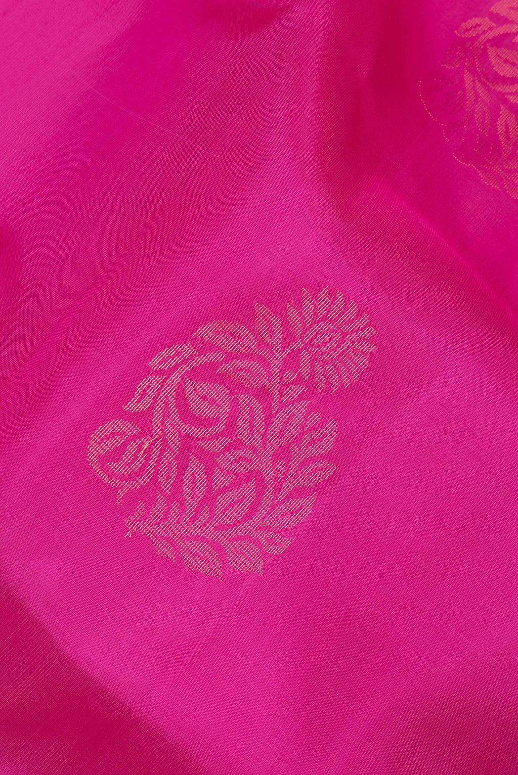 Close up of Pure Silk Dark Pink Soft Saree with Zari Butta on the body and Zari Border.  displaying folds