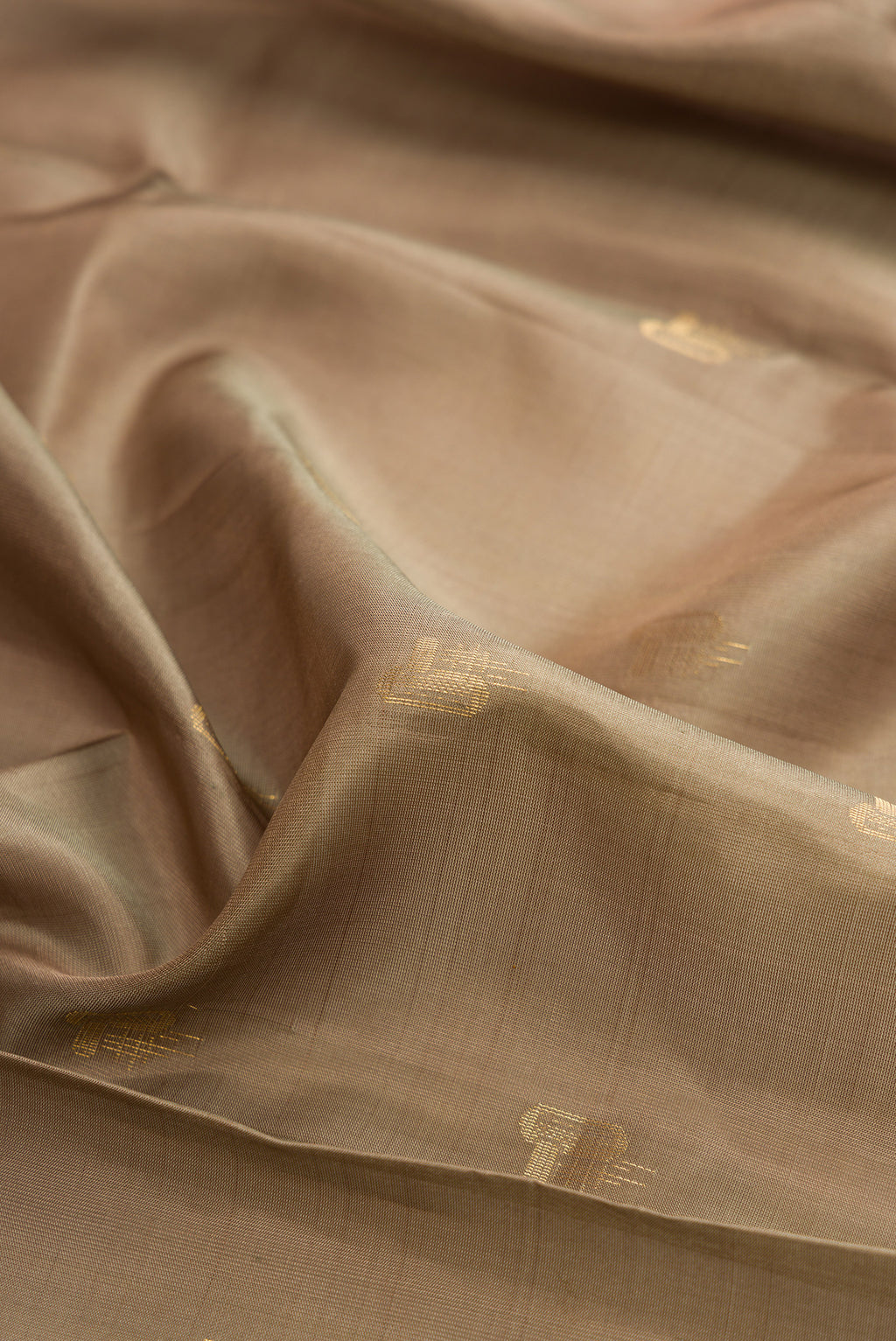 Close up of Pure Silk Dark Beige Soft Saree with Zari Butta on the body and Zari Border.  displaying folds