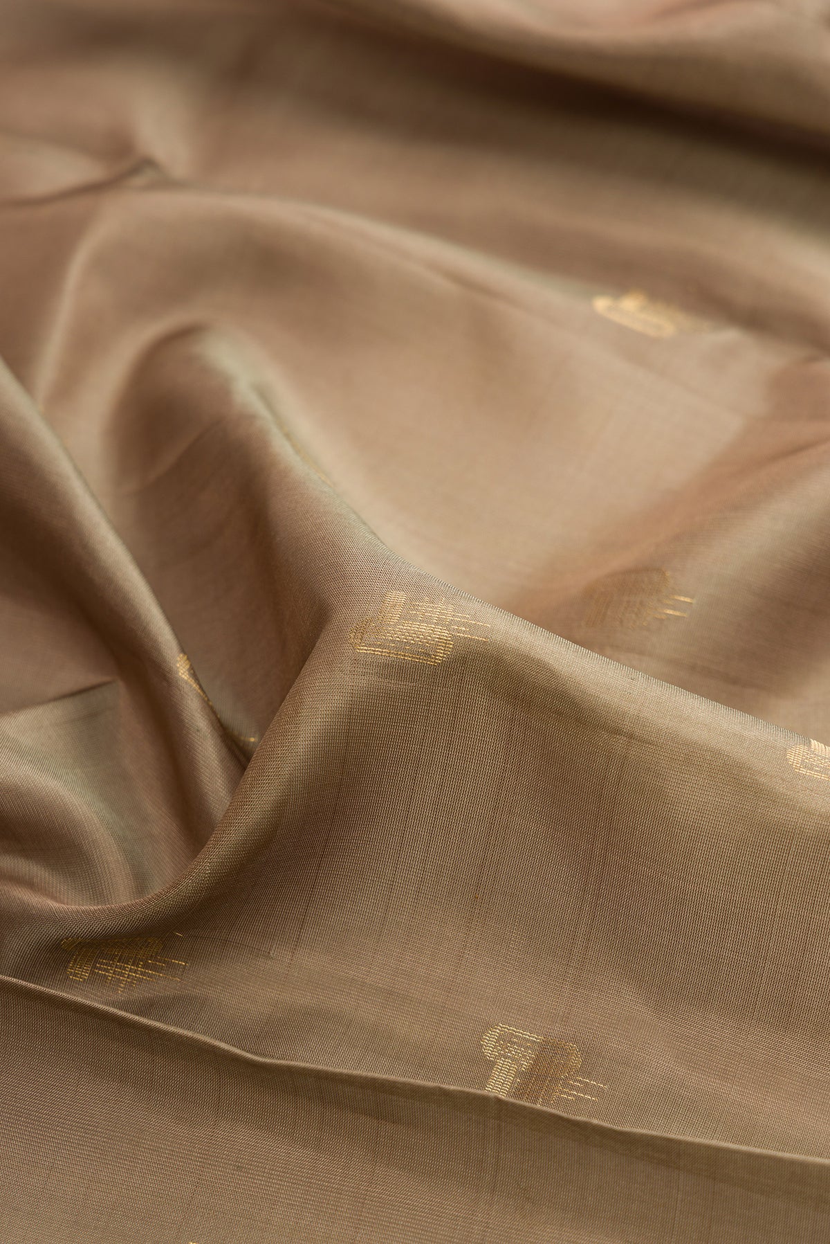 Close up of Pure Silk Dark Beige Soft Saree with Zari Butta on the body and Zari Border.  displaying folds
