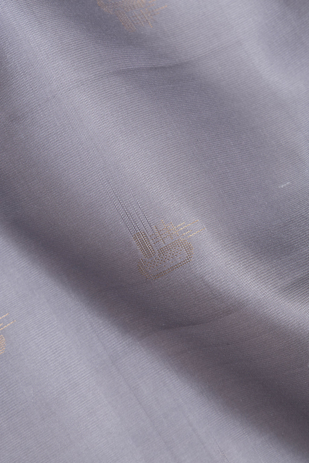 Close up of Pure Silk Grey Soft Saree with Zari Butta on the body and Zari Border.  displaying folds