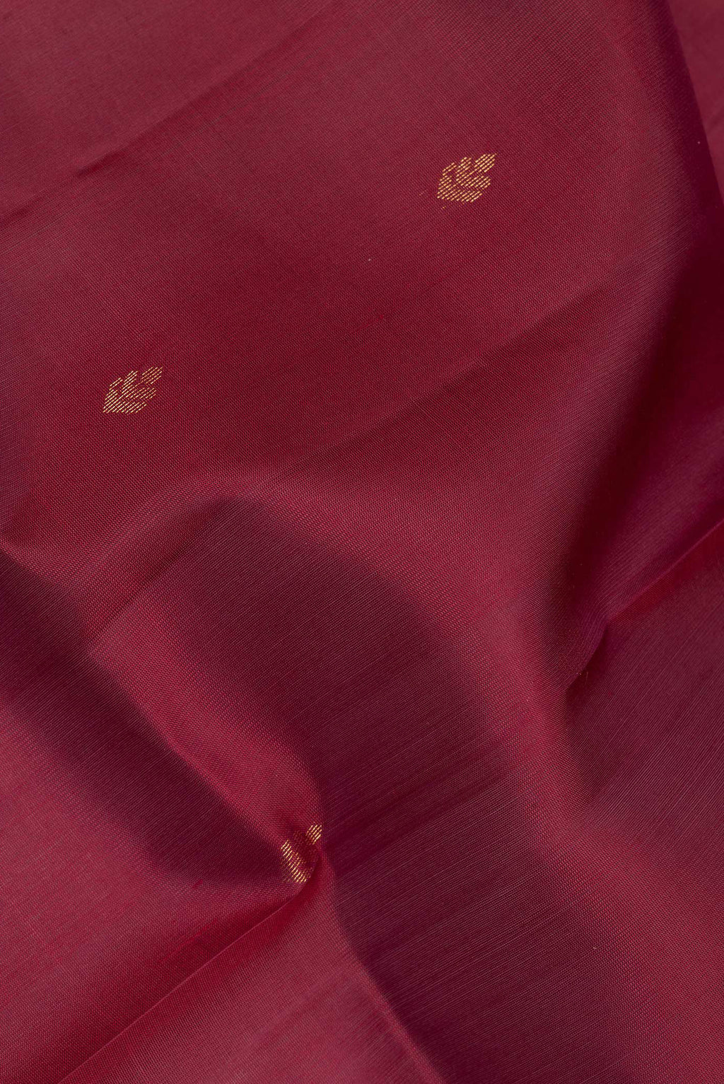 Close up of Pure Silk Maroon Soft Saree with Zari Butta on the body and Zari Border.  displaying folds