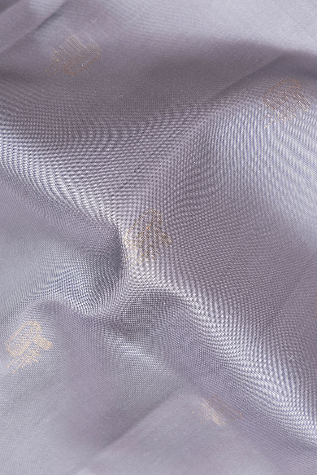 Close up of Pure Silk Grey Dual Tone Soft Saree with Zari Butta on the body and Zari Border.  displaying folds