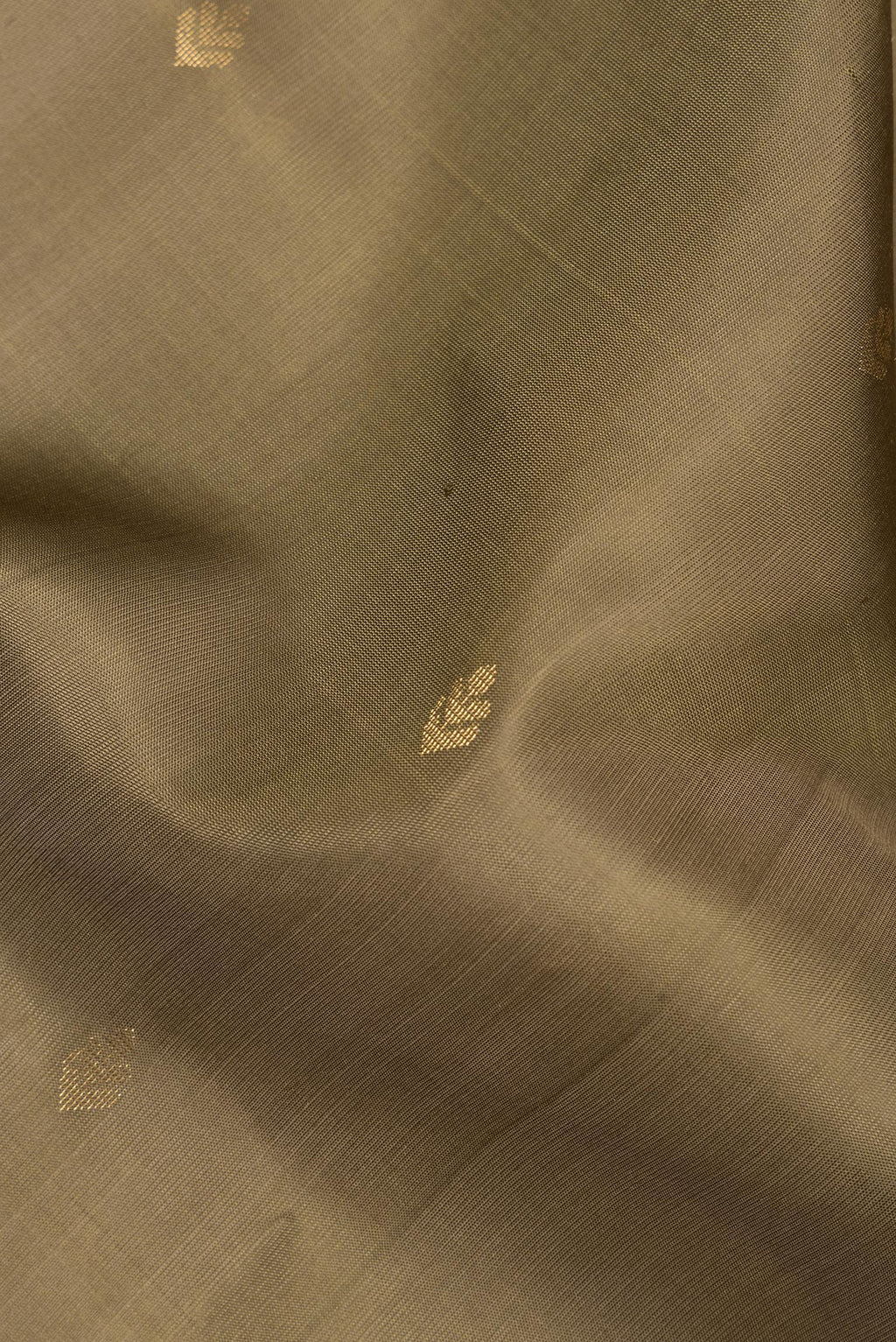 Close up of Pure Silk Mehandi Green Soft Saree with Zari Butta on the body and Zari Border.  displaying folds