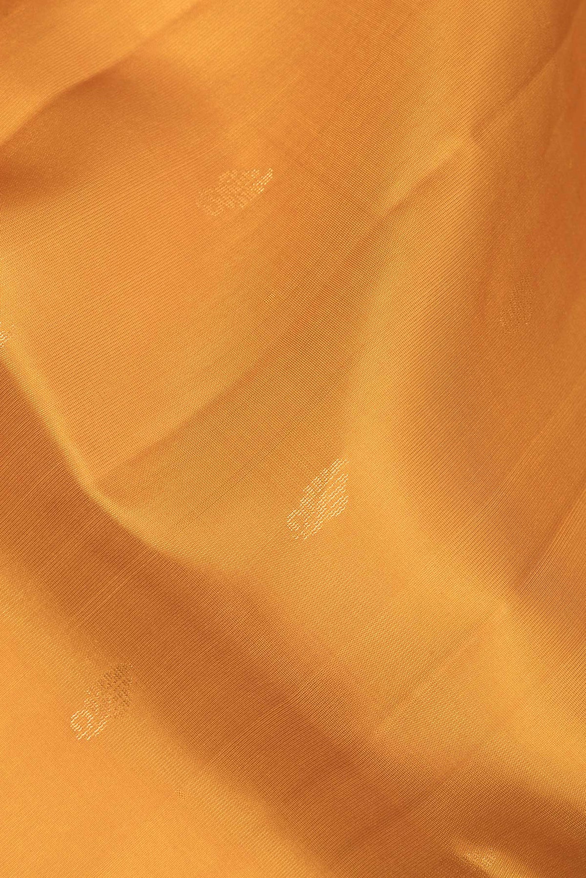 Close up of Pure Silk Mustard Soft Saree with Zari Butta on the body and Zari Border.  displaying folds