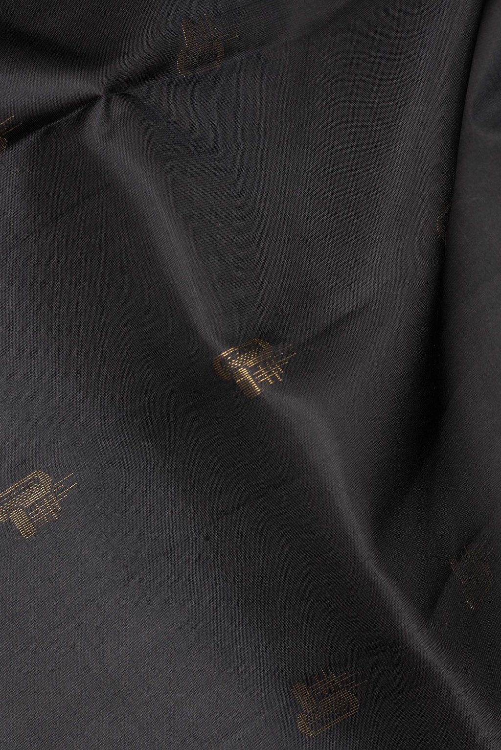 Close up of Pure Silk Black Soft Saree with Zari Butta on the body and Zari Border.  displaying folds