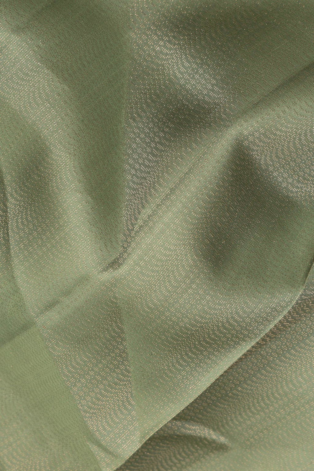 Close up of Pure Silk Sage Green Soft Saree with Zari Brocade on the body and Fancy Border.  displaying folds