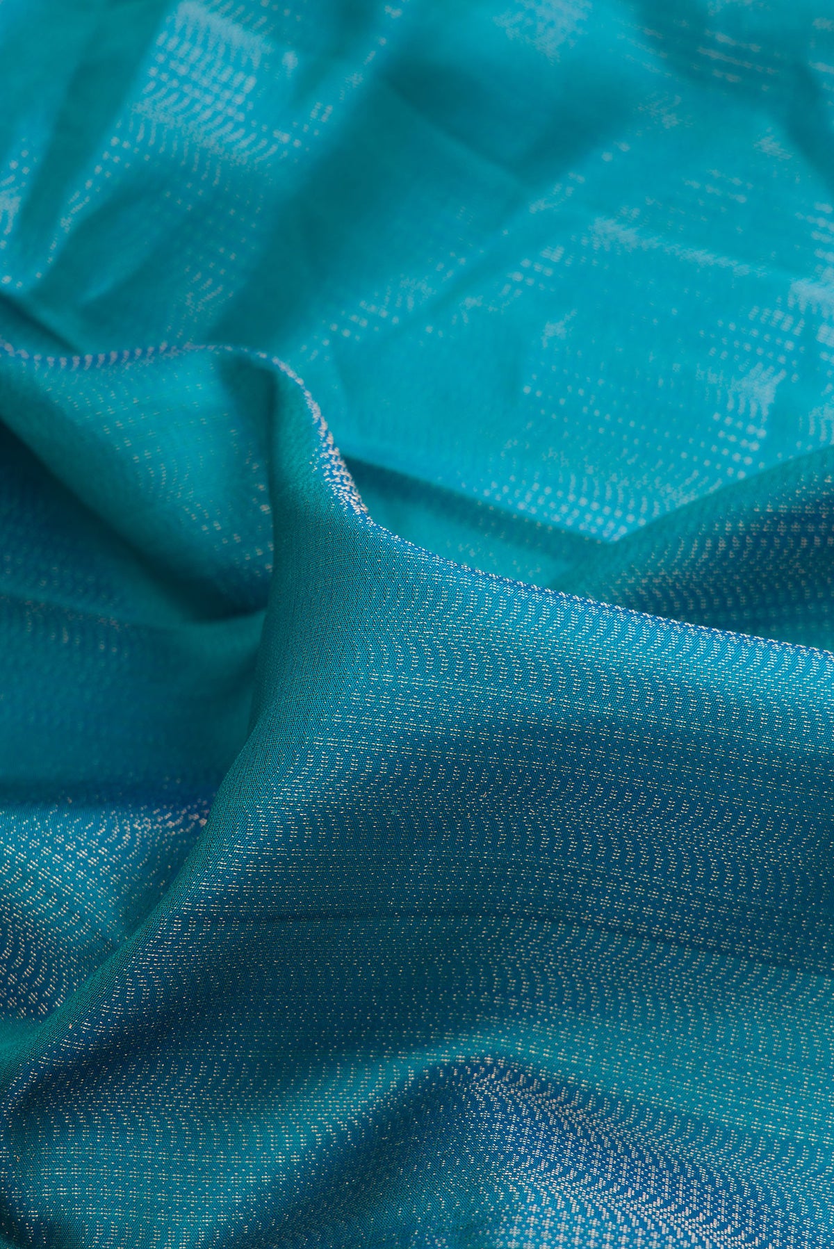Close up of Pure Silk Peacock Blue Soft Saree with Zari Brocade on the body and Fancy Border.  displaying folds