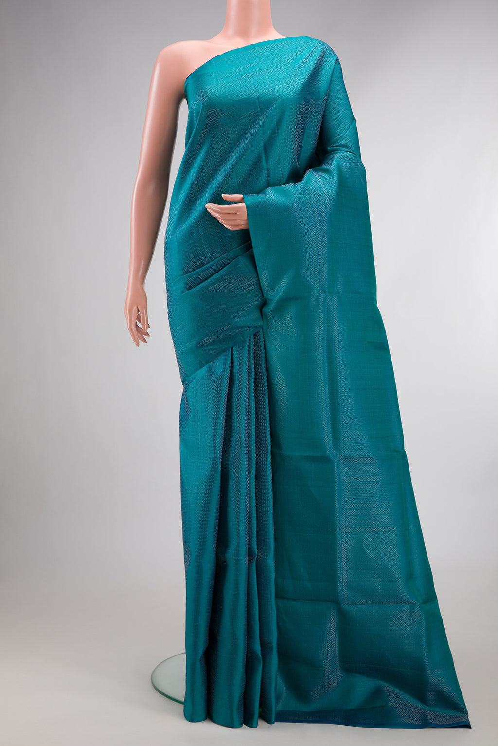Pure Silk Peacock Blue Soft Saree with Zari Brocade on the body and Fancy Border.  displayed on a mannequin