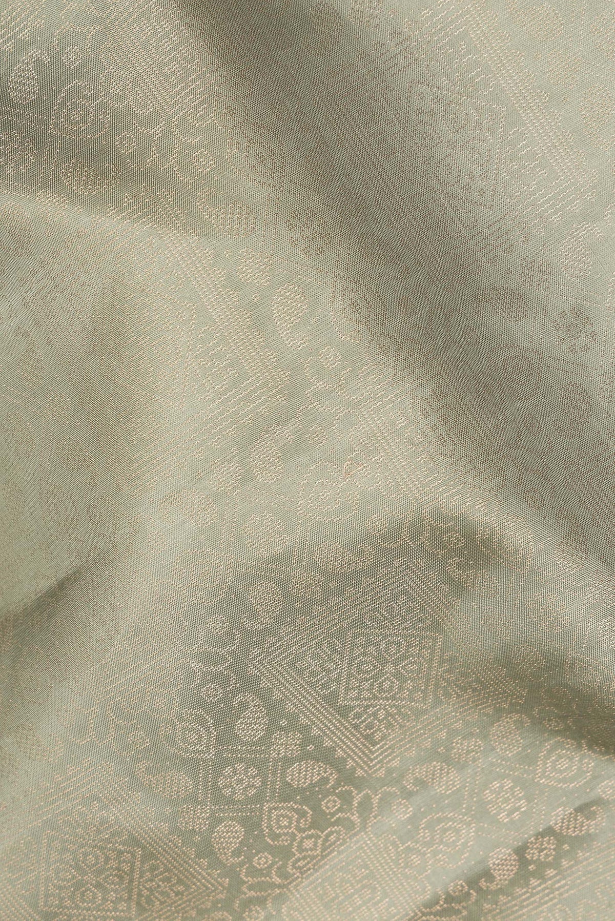 Close up of Pure Silk Sage Green Soft Saree with Zari Brocade on the body and Fancy Border.  displaying folds