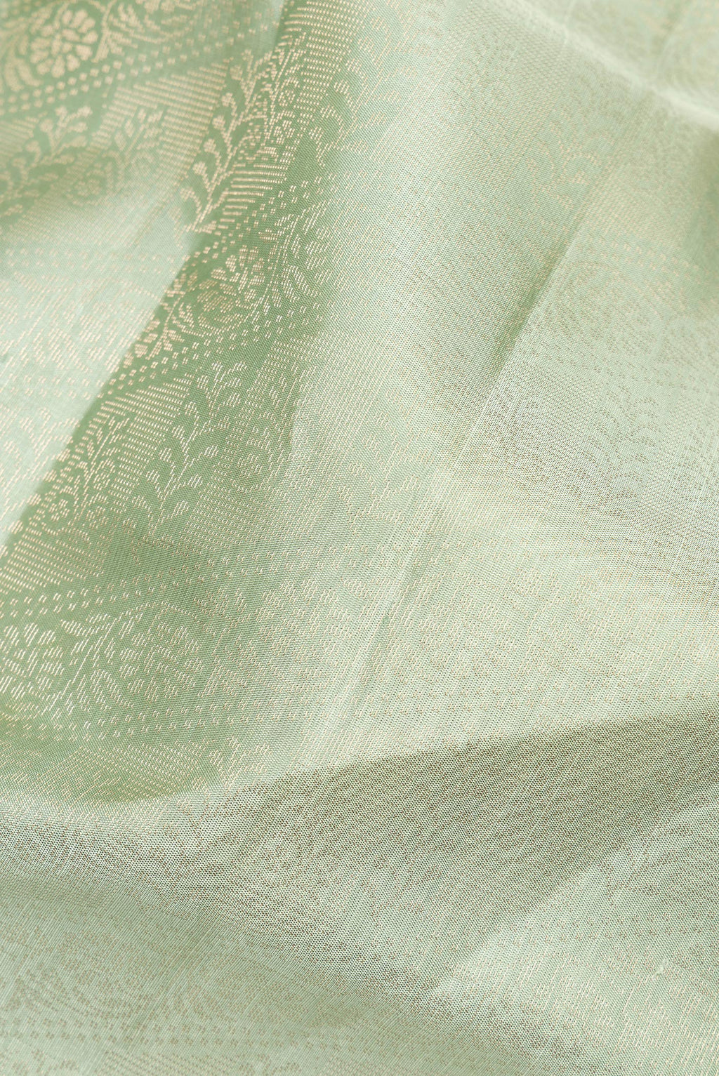 Close up of Pure Silk Pista Green Soft Saree with Zari Brocade on the body and Fancy Border.  displaying folds
