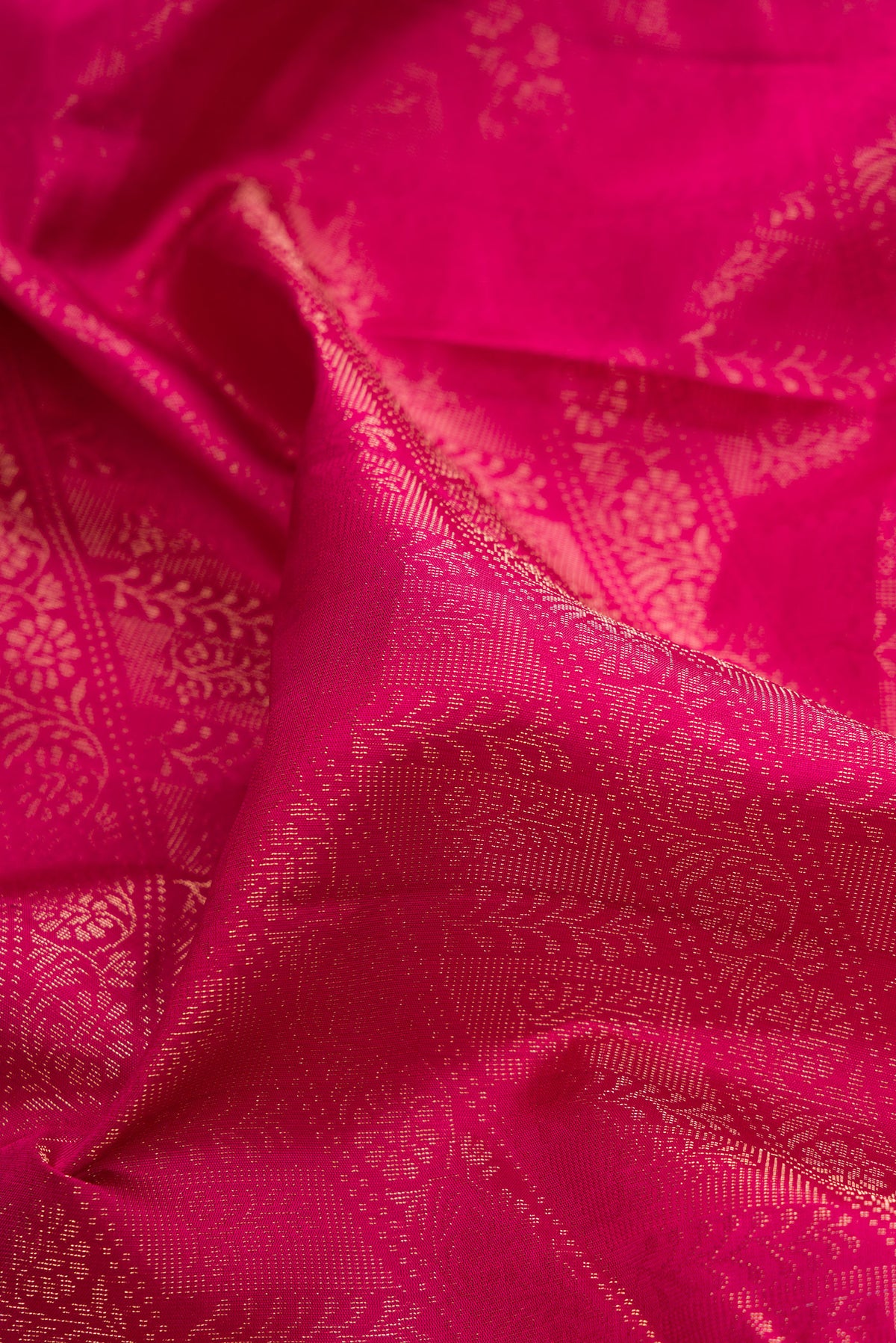 Close up of Pure Silk Dark Pink Soft Saree with Zari Brocade on the body and Fancy Border.  displaying folds
