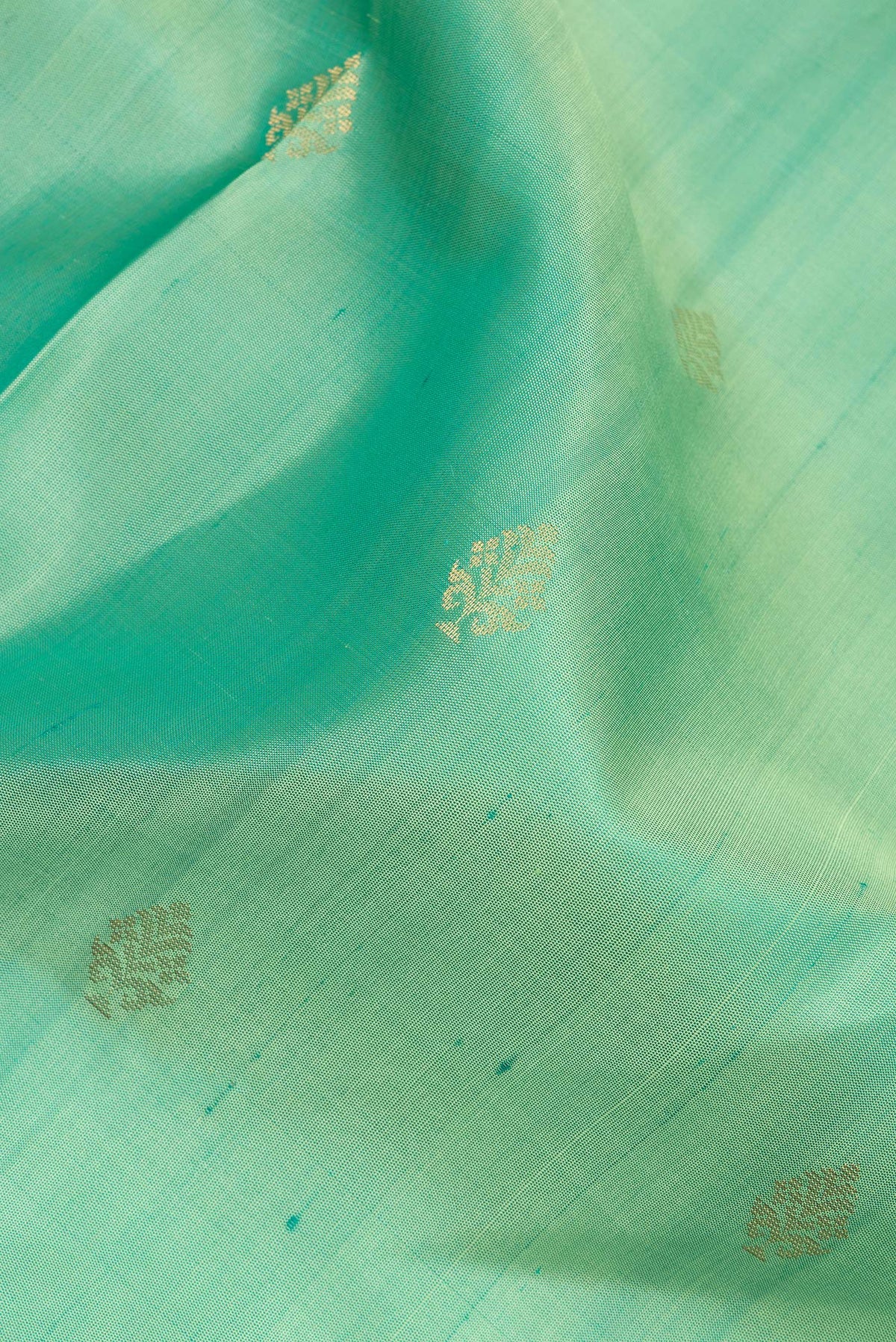 Close up of Pure Silk Green Soft Saree with Zari Butta on the body and Zari Border.  displaying folds