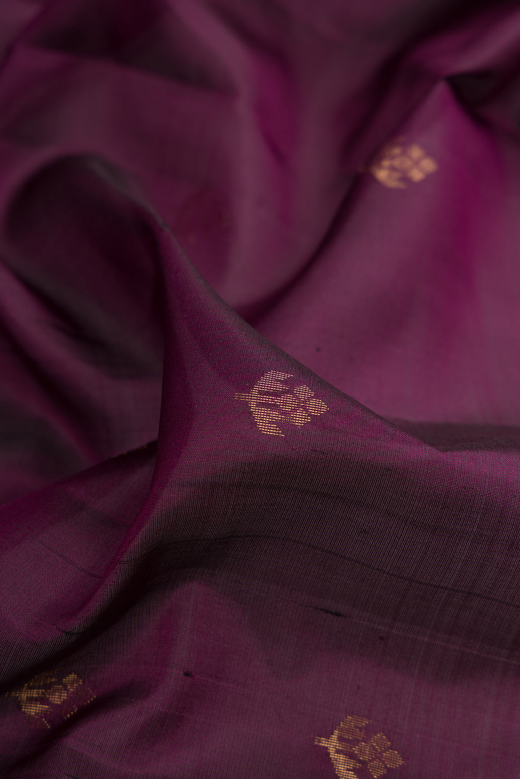 Close up of Pure Silk Burgundy Soft Saree with Zari Butta on the body and Zari Border.  displaying folds