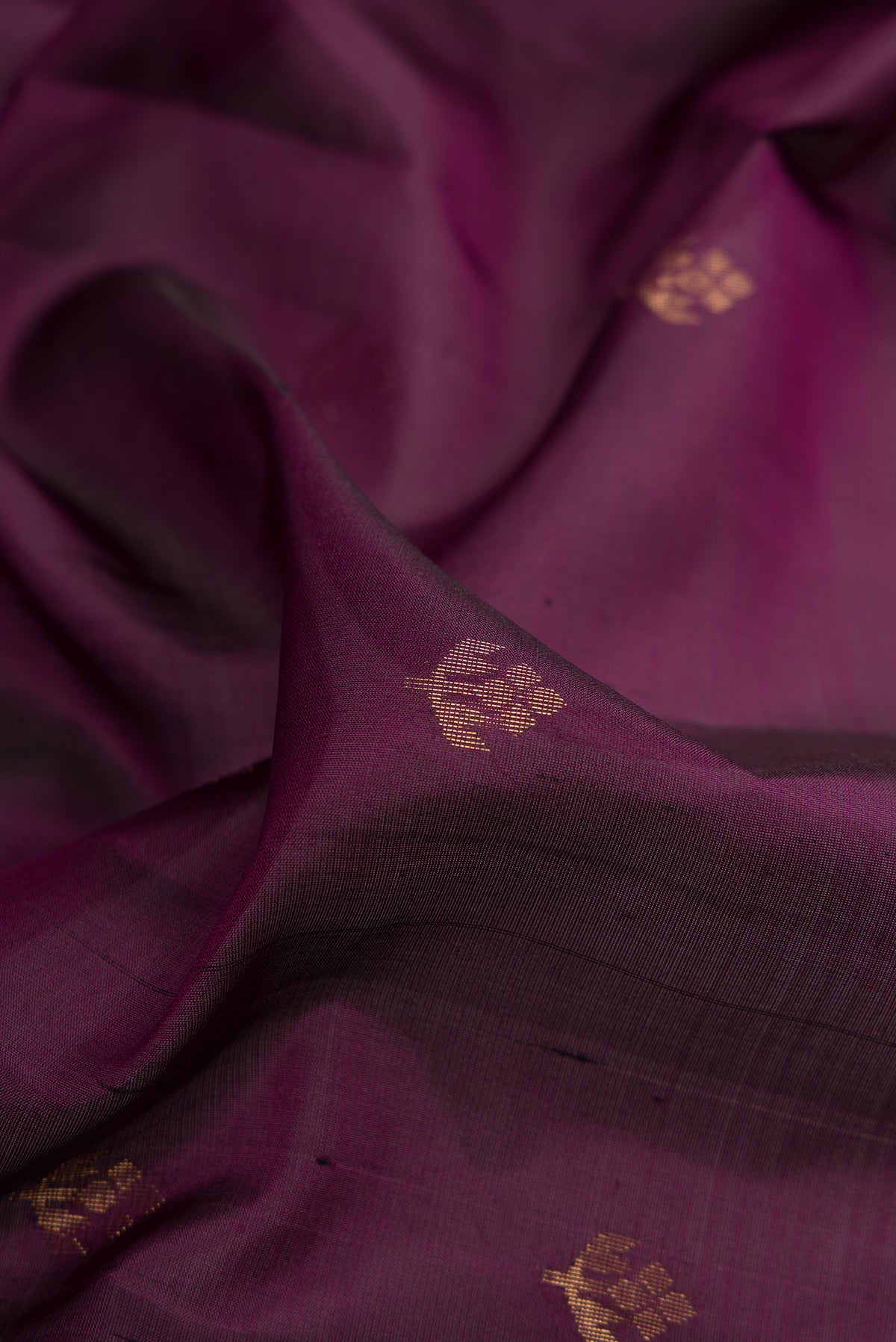 Close up of Pure Silk Burgundy Soft Saree with Zari Butta on the body and Zari Border.  displaying folds
