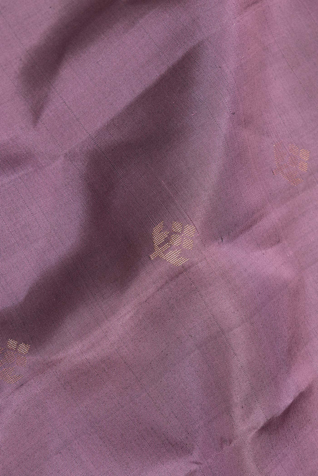 Close up of Pure Silk Mauve Soft Saree with Zari Butta on the body and Zari Border.  displaying folds