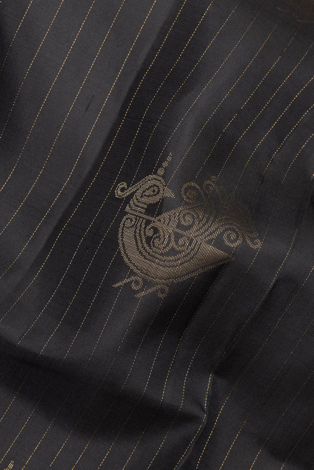 Close up of Pure Silk Black Soft Saree with Zari Butta on the body and Without Border.  displaying folds