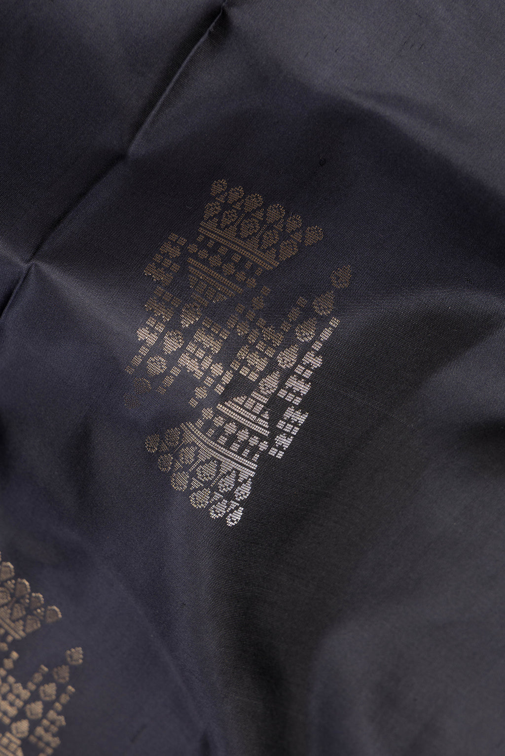 Close up of Pure Silk Black Soft Saree with Zari Butta on the body and Zari Border.  displaying folds