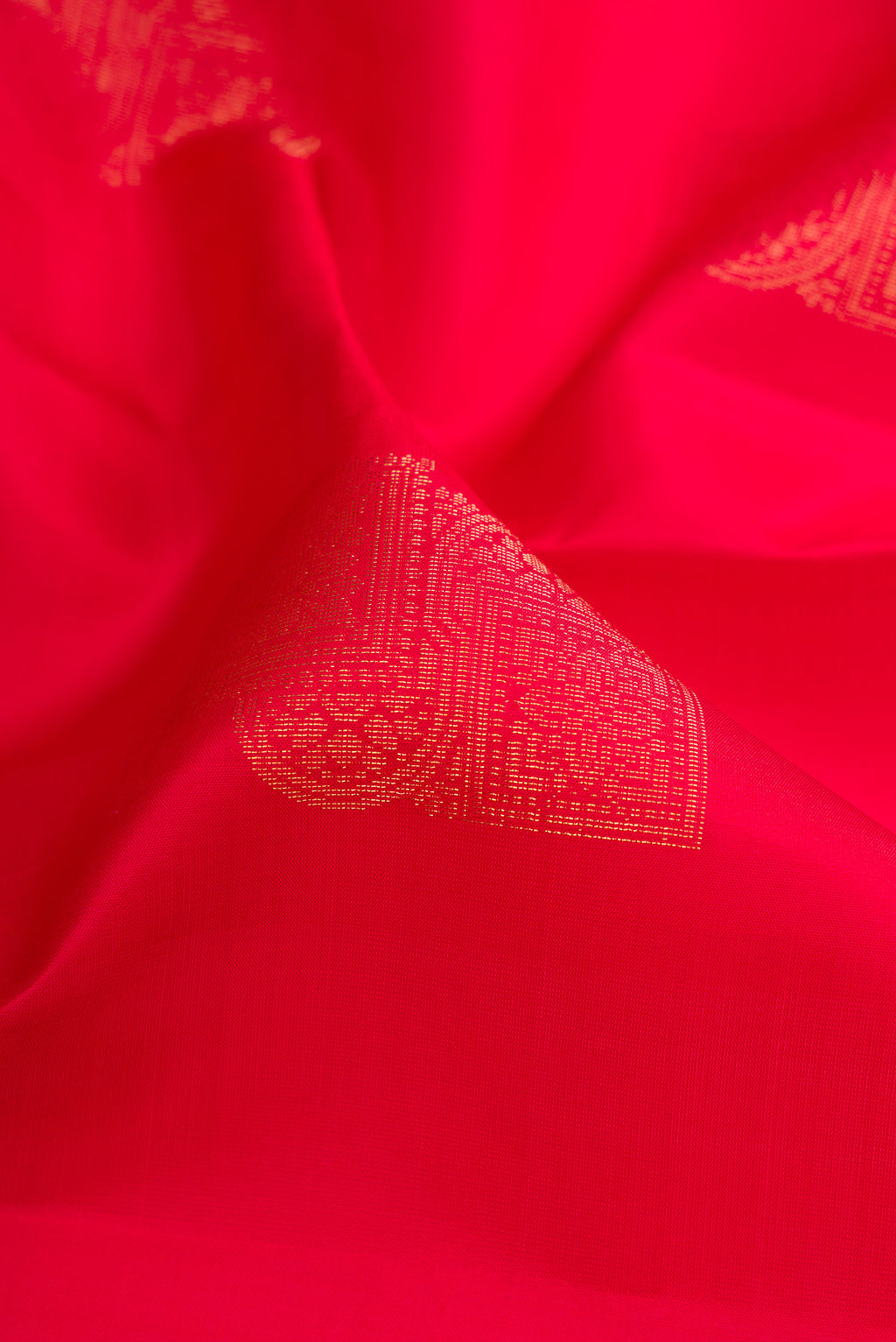 Close up of Pure Silk Red Soft Saree with Zari Butta on the body and Without Border.  displaying folds