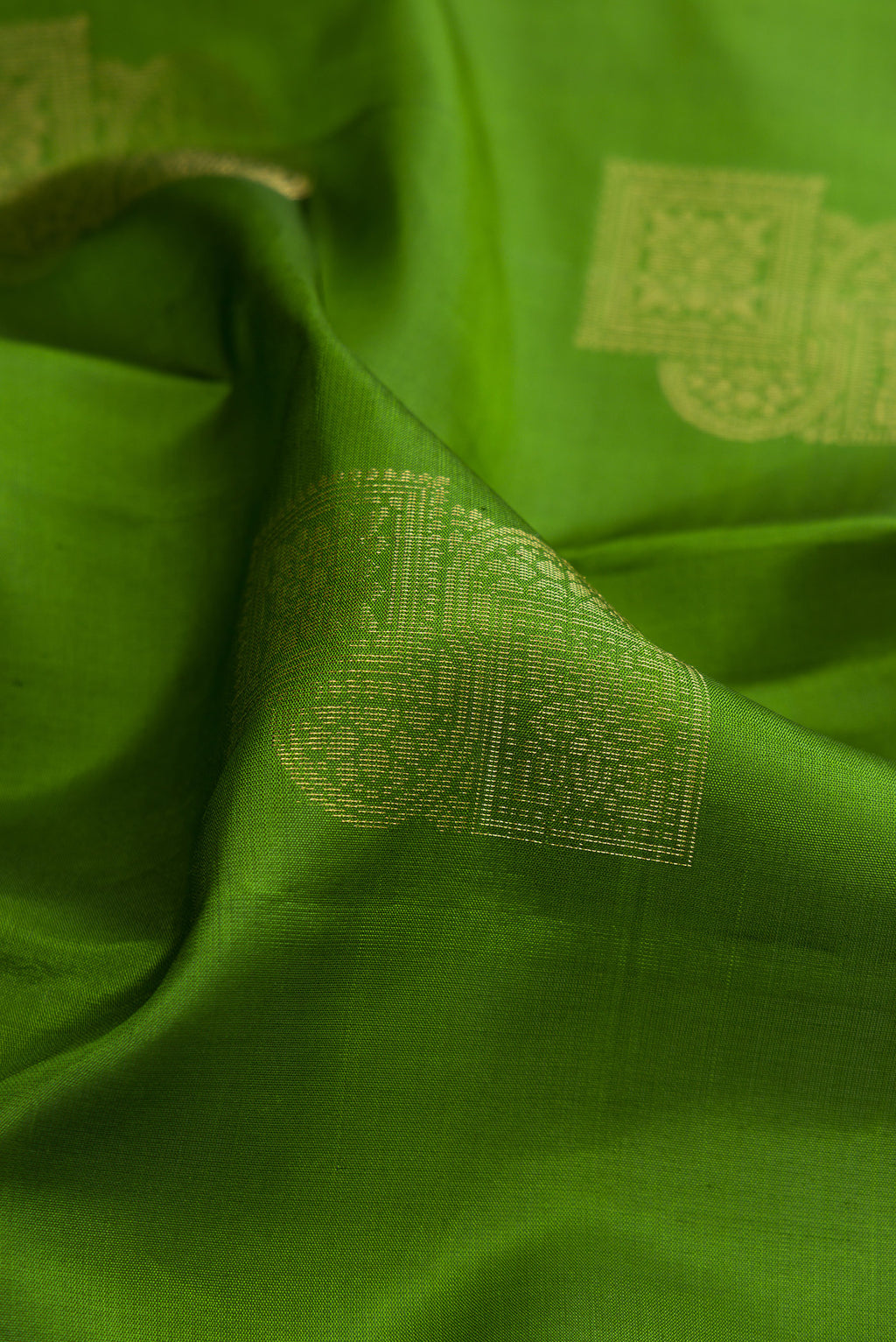 Close up of Pure Silk Green Soft Saree with Zari Butta on the body and Without Border.  displaying folds