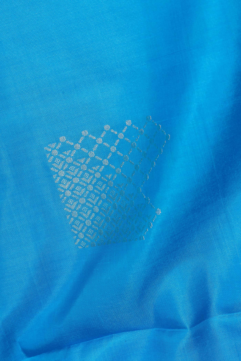 Close up of Pure Silk Sky Blue Soft Saree with Zari Butta on the body and Zari Border.  displaying folds