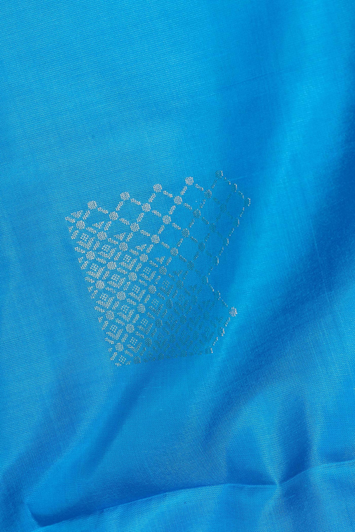 Close up of Pure Silk Sky Blue Soft Saree with Zari Butta on the body and Zari Border.  displaying folds